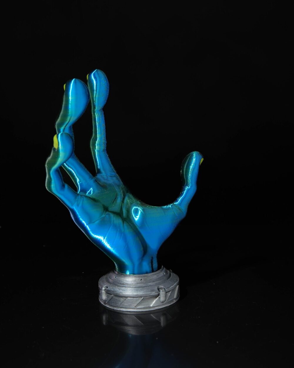 4-Finger Alien Hand Controller Holder in blue and green hues, displayed against a black background with a gray base.