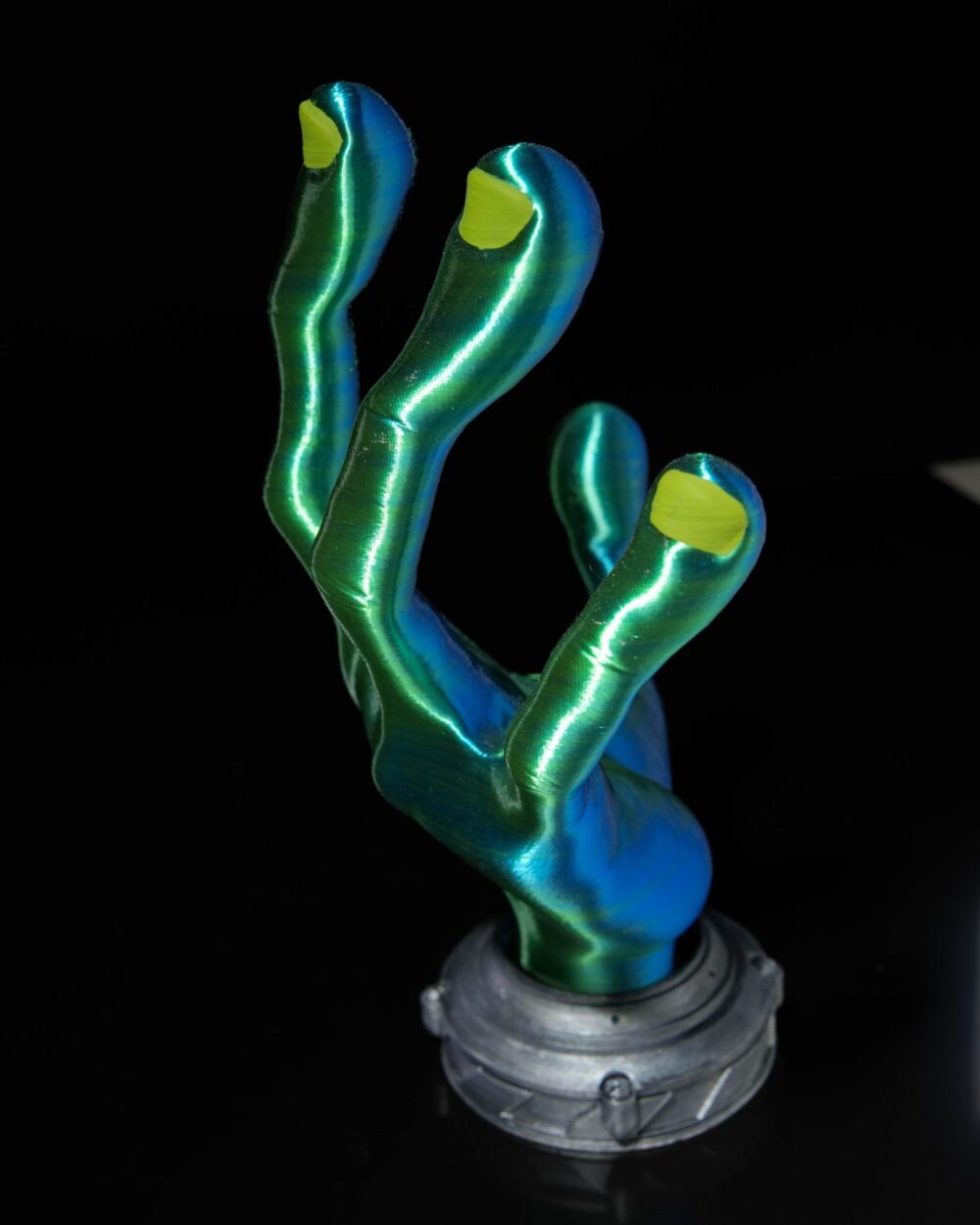 4-Finger Alien Hand Controller Holder with green metallic finish and yellow fingertips, standing upright on a black background.