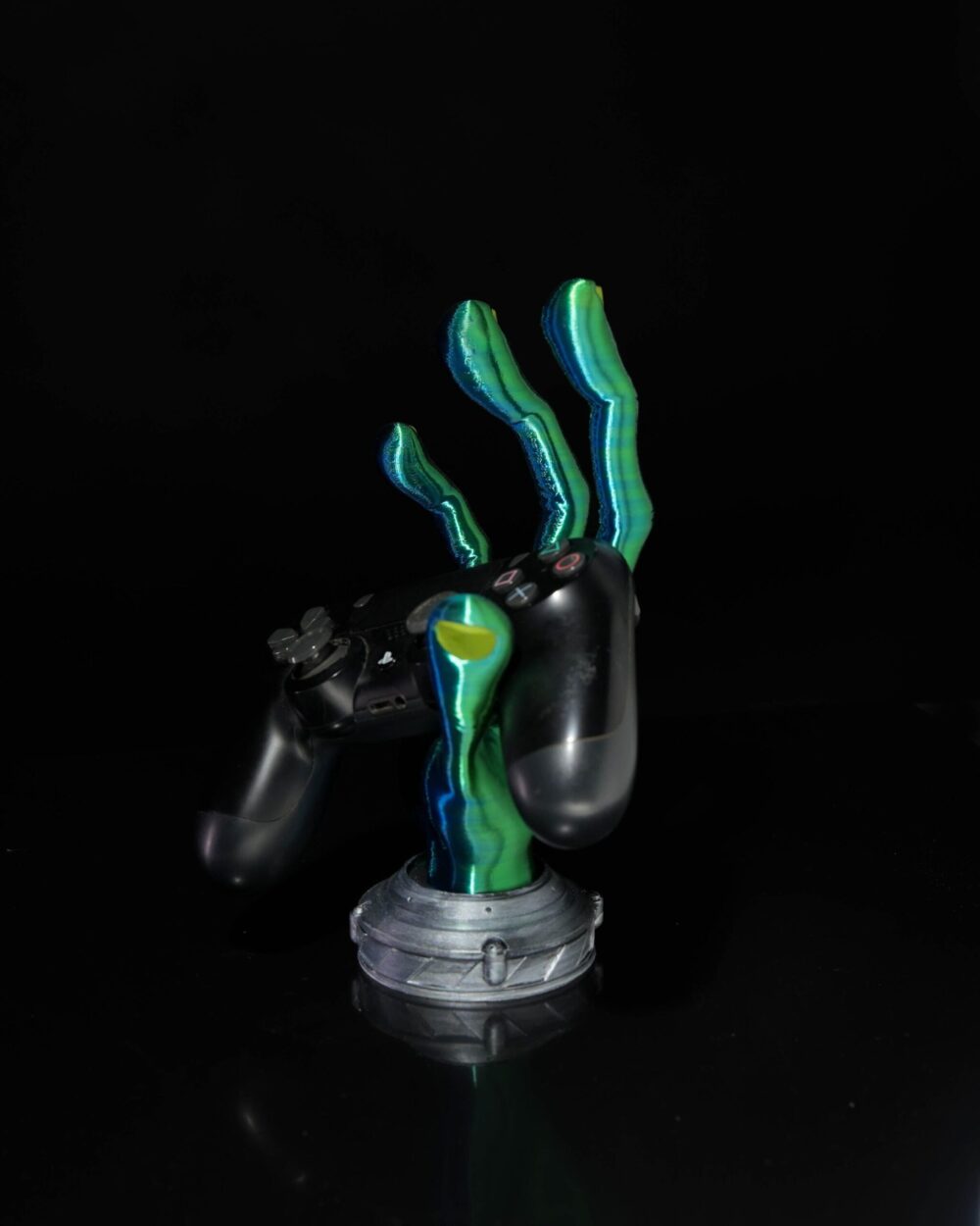 4-Finger Alien Hand Controller Holder displaying a gaming controller, with green and blue fingers on a black background.