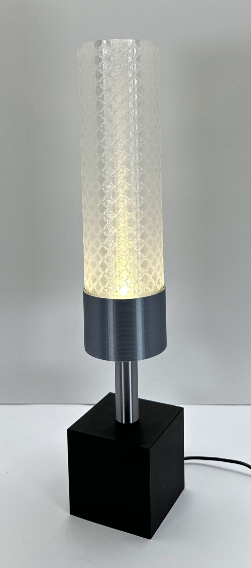 Elegant Modern Cylinder Lamp with a sleek minimalist design, featuring a textured cylindrical shade and black square base.