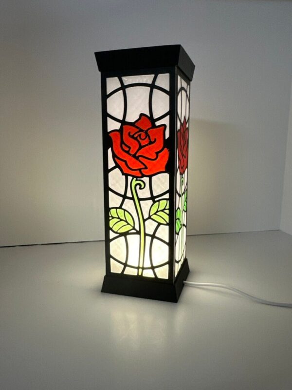 Stunning stained glass lantern featuring a red rose design, lit from within. Ideal for home decor or as a unique gift.